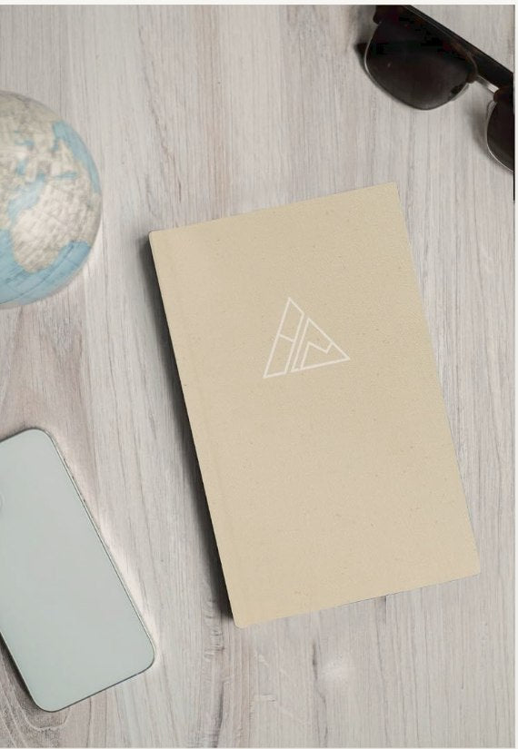 Self-Mastery Journal on a light wood desk beside a globe and sunglasses